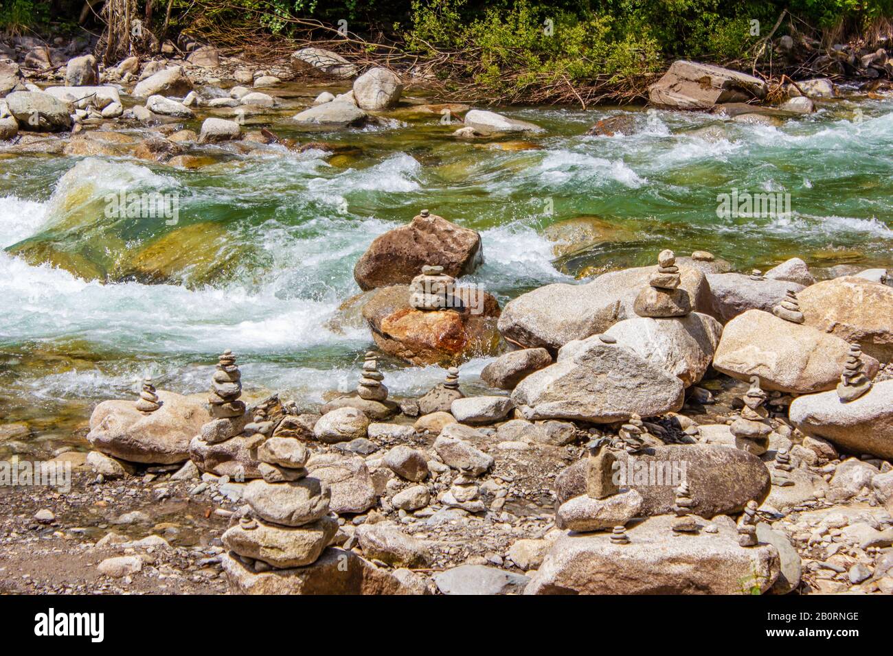 Harmonie, équilibre et simplicité concept. Une pyramide de pierre sur le fond de l'eau de rivière. Galets poise simples, rock zen. Bleu, vie. Banque D'Images