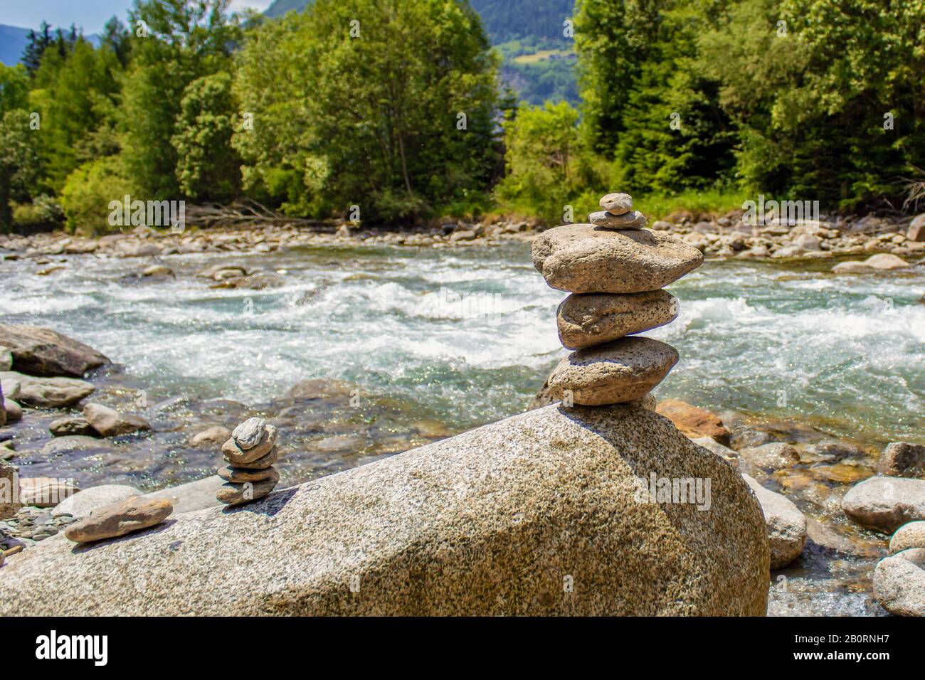 Harmonie, équilibre et simplicité concept. Une pyramide de pierre sur le fond de l'eau de rivière. Galets poise simples, rock zen. Bleu, vie. Banque D'Images