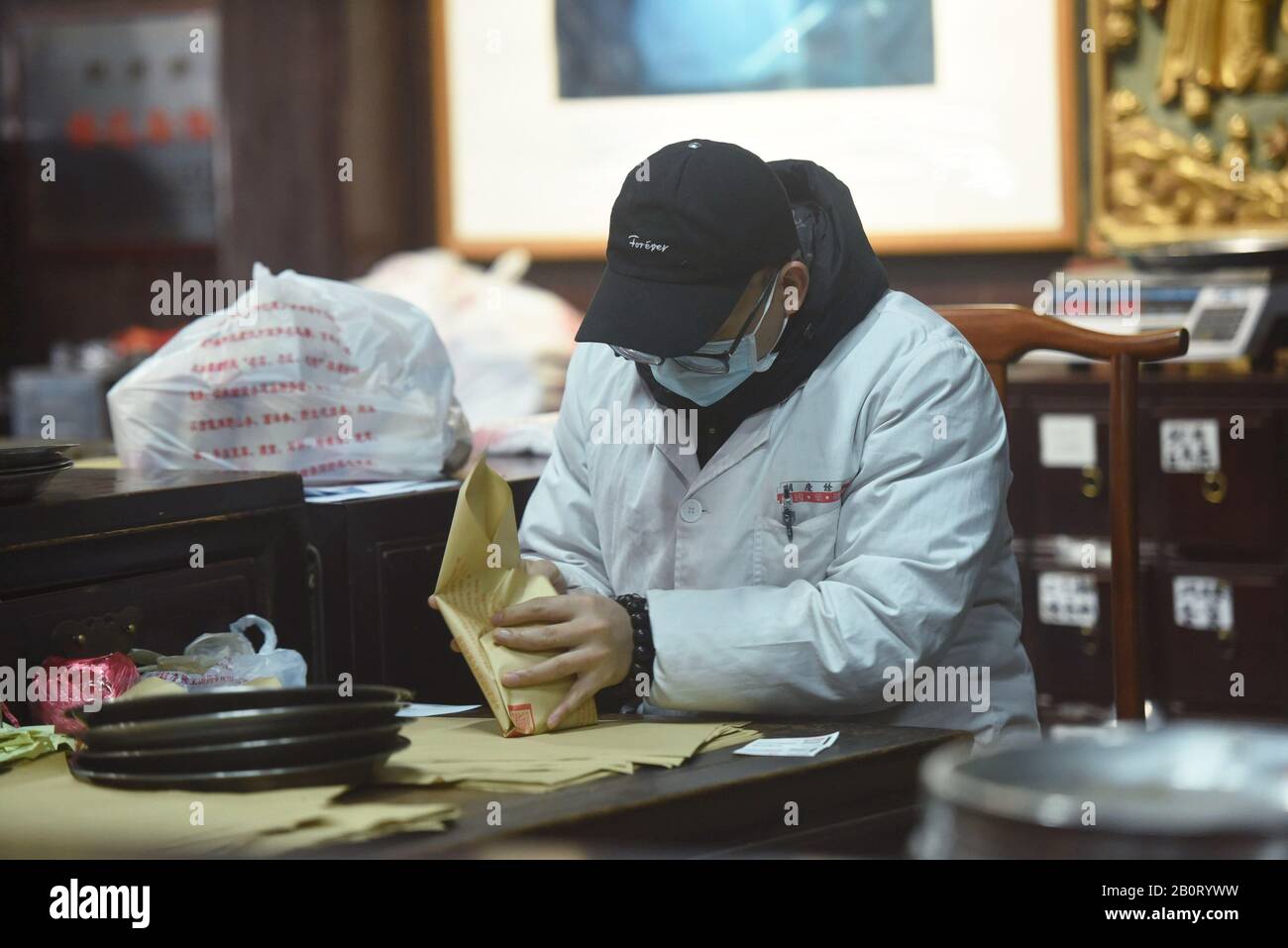 Un employé chinois dispense une médecine traditionnelle chinoise à base de plantes (TCM) pour la prévention du nouveau coronavirus et de la pneumonie dans une pharmacie à Hangzhou C Banque D'Images