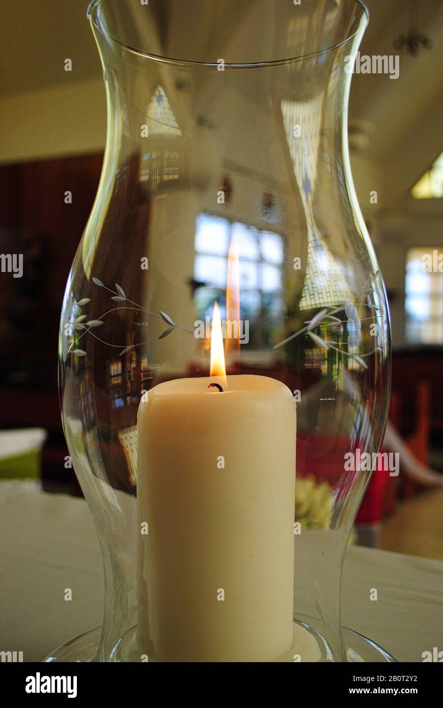 Gros plan d'une grande bougie éclairée dans un vase en verre à l'intérieur d'une  église Photo Stock - Alamy