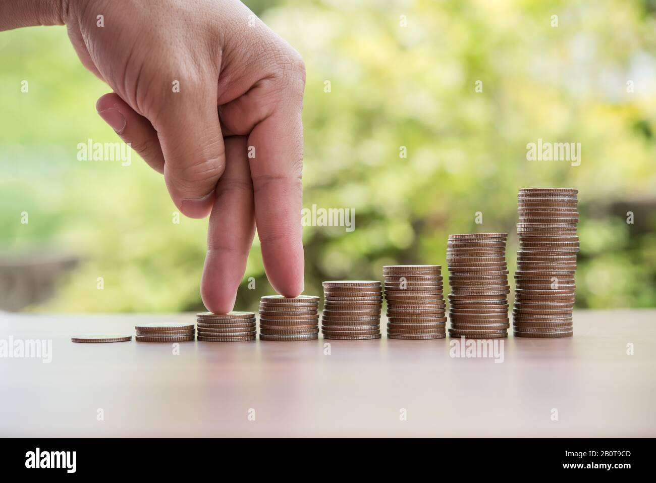 Les doigts marchent sur la pile de pièces ou la pile d'argent Banque D'Images