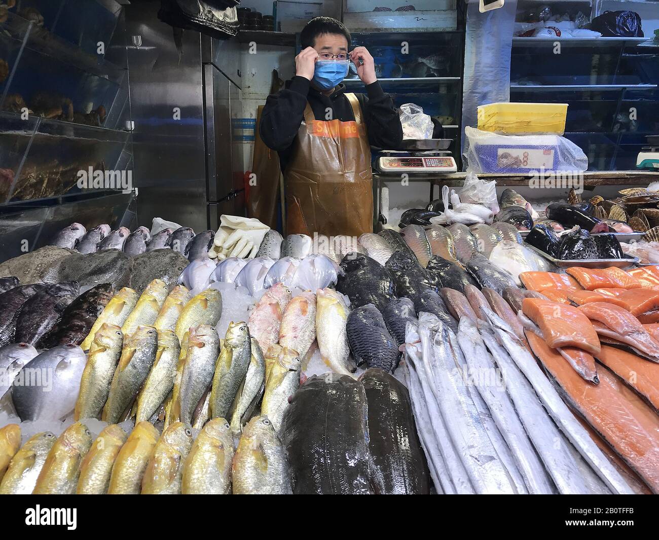 Pékin, Chine. 21 février 2020. Un poissonnier porte un masque protecteur sur un marché presque vide, car la menace du coronavirus mortel (Covid-19) qui se propage à Beijing se poursuit le vendredi 21 février 2020. La capitale chinoise a ordonné à quiconque retournait dans la ville d'être mis en quarantaine pendant 14 jours ou de punir les personnes à risque dans le but de contenir le coronavirus. Le nombre de morts est proche de 2 300 personnes et a infecté plus de 76 600 personnes dans 28 pays. Photo de Stephen Shaver/UPI Credit: UPI/Alay Live News Banque D'Images