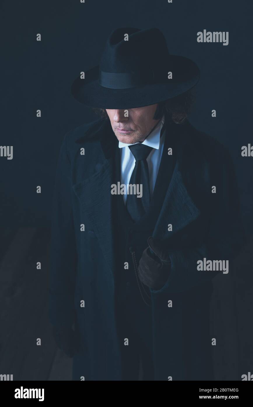 Mystérieux homme victorien en manteau noir et chapeau Photo Stock - Alamy
