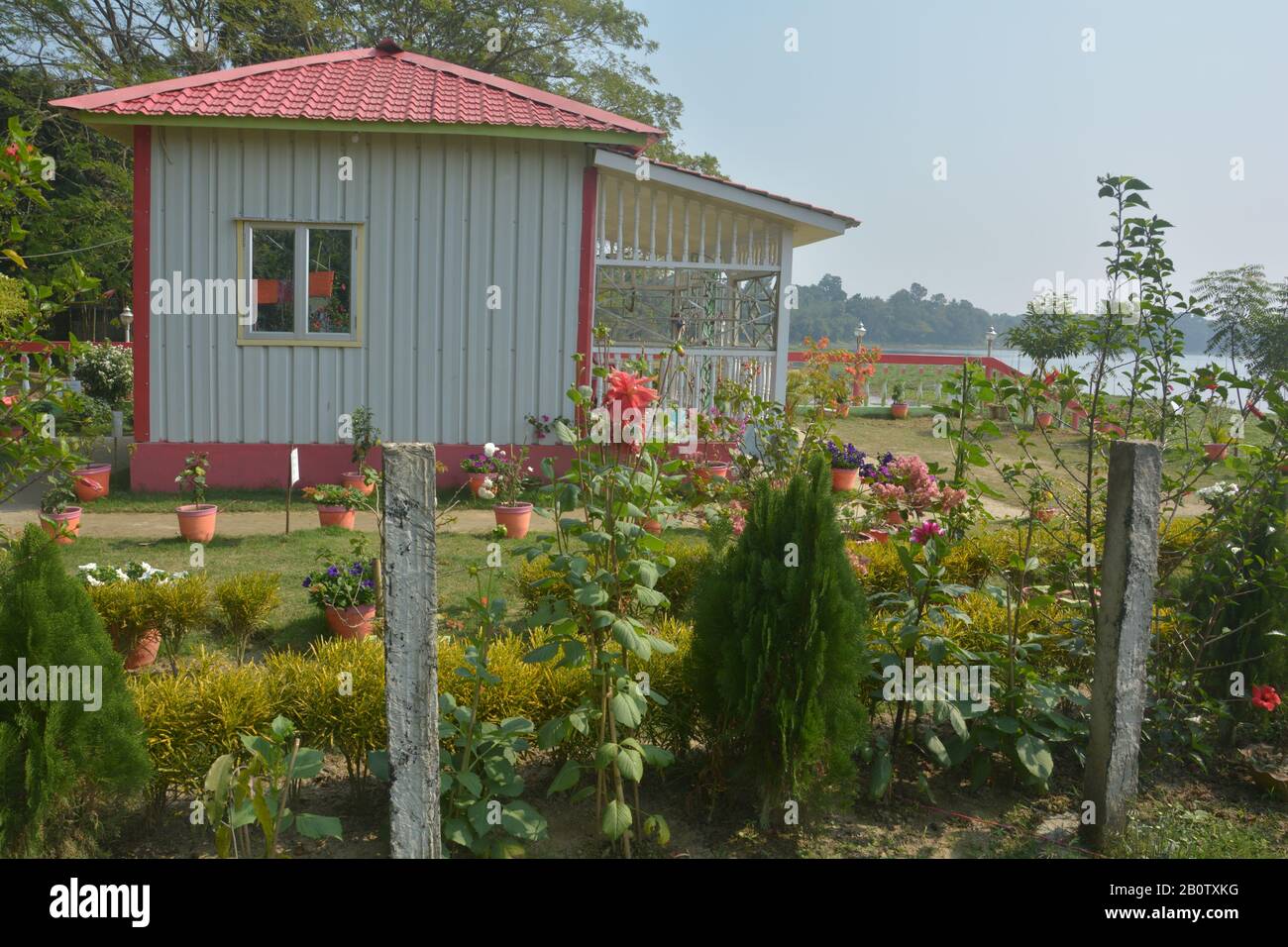 Gros plan d'une petite maison préfabriquée avec un toit en carrelage en matériau synthétique et un mur blanc de préfibres avec beau jardin Banque D'Images