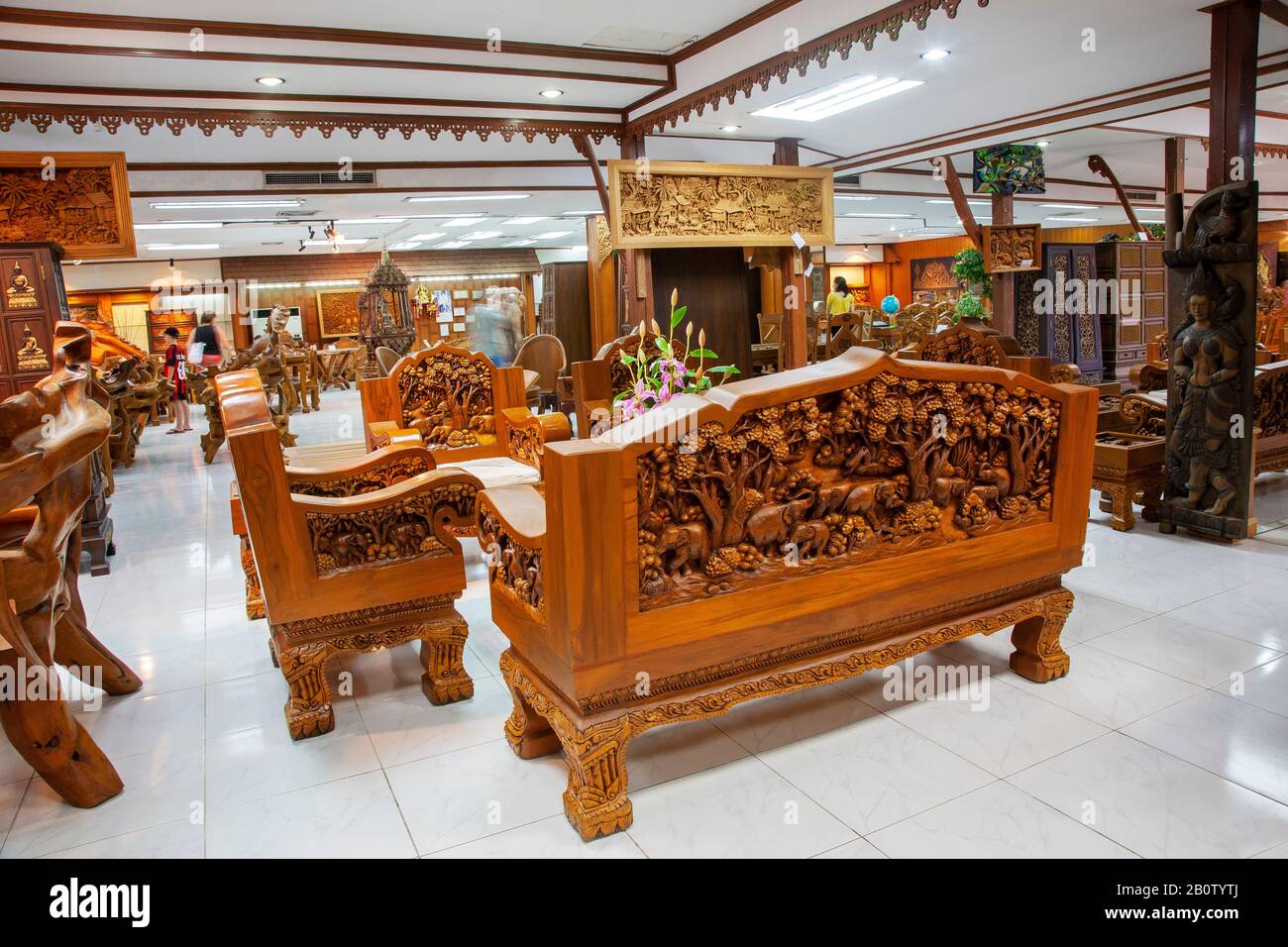 Table et chaises artisanales asiatiques dans l'atelier de mobilier : une attraction touristique produisant des boiseries uniques en bois recyclé sculpté et réutilisé. Pièces ciselées à la main, savoir-faire raffiné avec art animal et paysage pour l'exportation, en Thaïlande: Une attraction touristique produisant unique sculpté réutilisé bois recyclé en bois. Pièces ciselées à la main, savoir-faire avec art animal et paysage pour l'exportation en Thaïlande, Royaume-Uni Banque D'Images