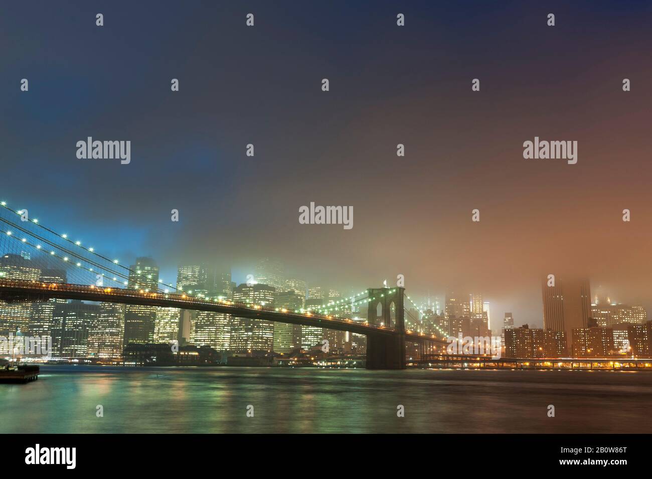 Gratte-ciel de Manhattan et pont de Brooklyn en brume au crépuscule, New York City, États-Unis Banque D'Images