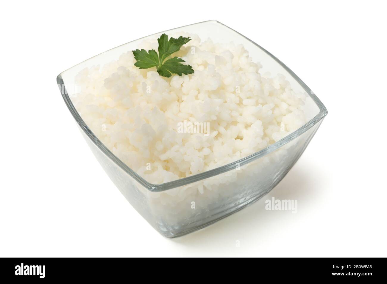 Bol en verre avec riz bouilli et persil isolé sur fond blanc Banque D'Images