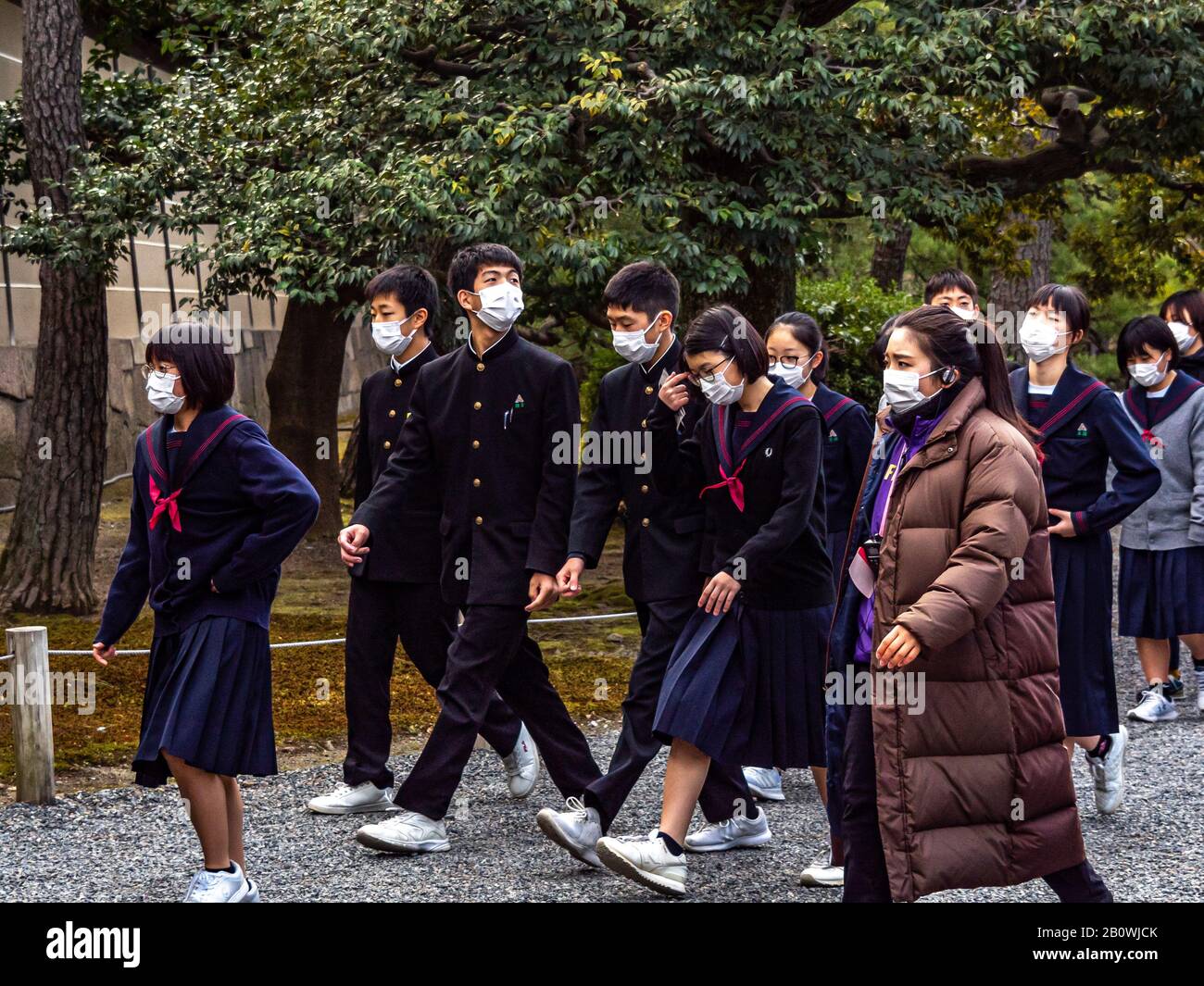 Les touristes japonais et les écoliers portent des masques de protection à l'ombre de l'éclosion de coronavirus. Banque D'Images