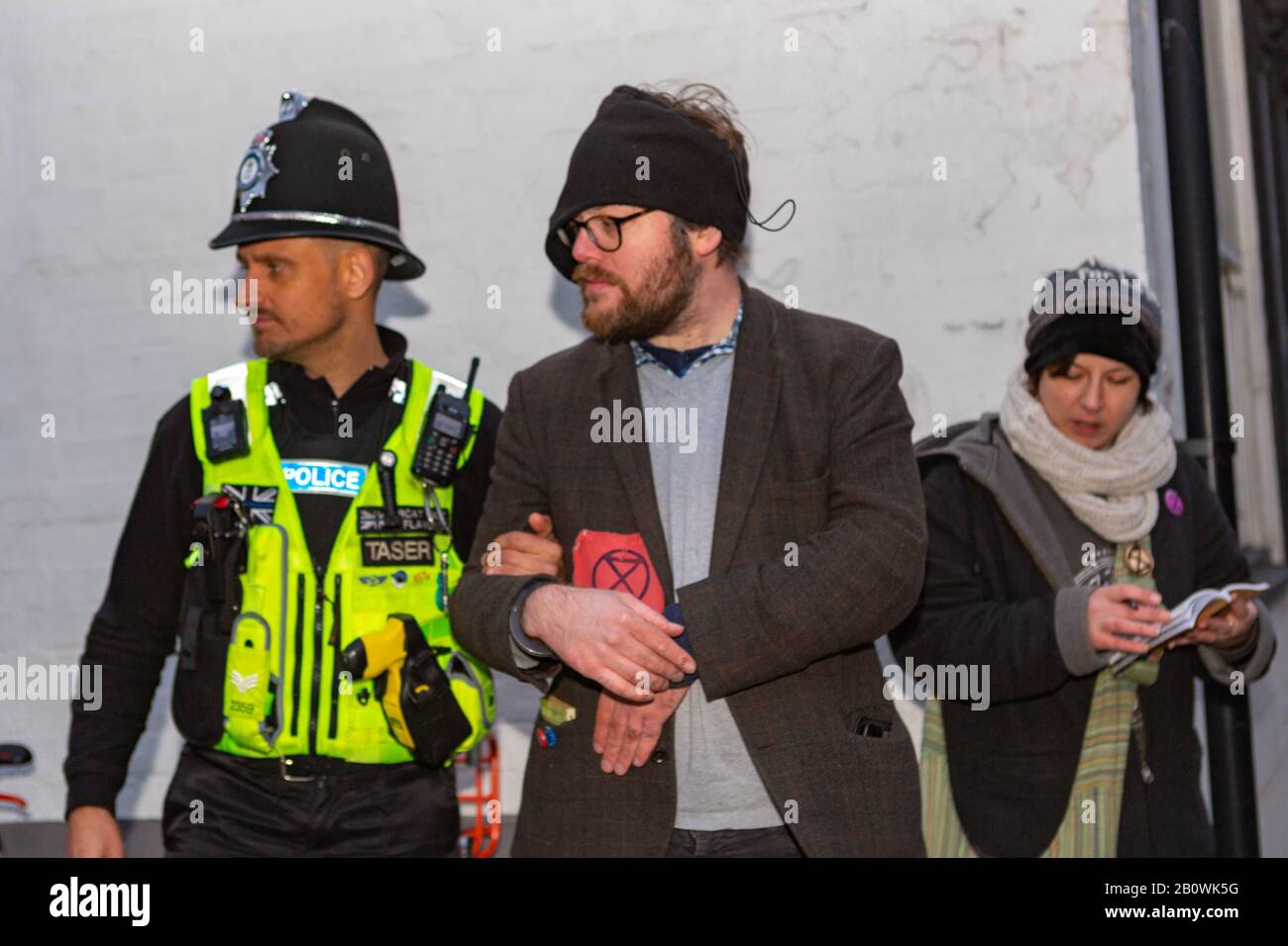 Cambridge, Royaume-Uni. 21 février 2020. La police arrête un activiste de la rébellion extinction devant le garage Shell sur Newnham Road, Cambridge. La manifestation cible les infrastructures de combustibles fossiles et met en lumière les préoccupations en matière de justice climatique. Un deuxième individu documente la scène dans le cadre de la démonstration. Penelope Barritt/Alamy Live News Banque D'Images