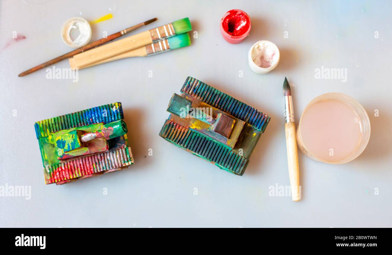 réservoir fait de carton coloré avec gouache par un enfant. réservoir de jouet se tient sur le lieu de travail des enfants parmi les peintures et les brosses. Banque D'Images