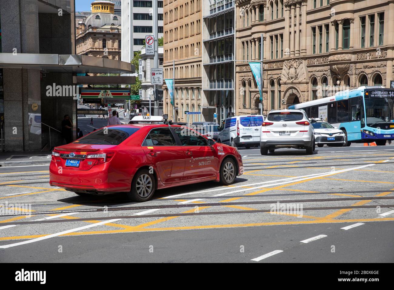 Sydney Red berline car taxi et Sydney bus dans le centre ville, Australie Banque D'Images