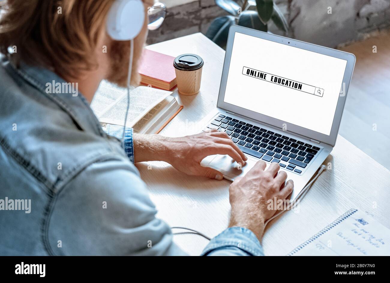 Au-dessus de l'épaule gros plan voir l'homme en utilisant la recherche d'ordinateur portable en ligne cours d'éducation Banque D'Images