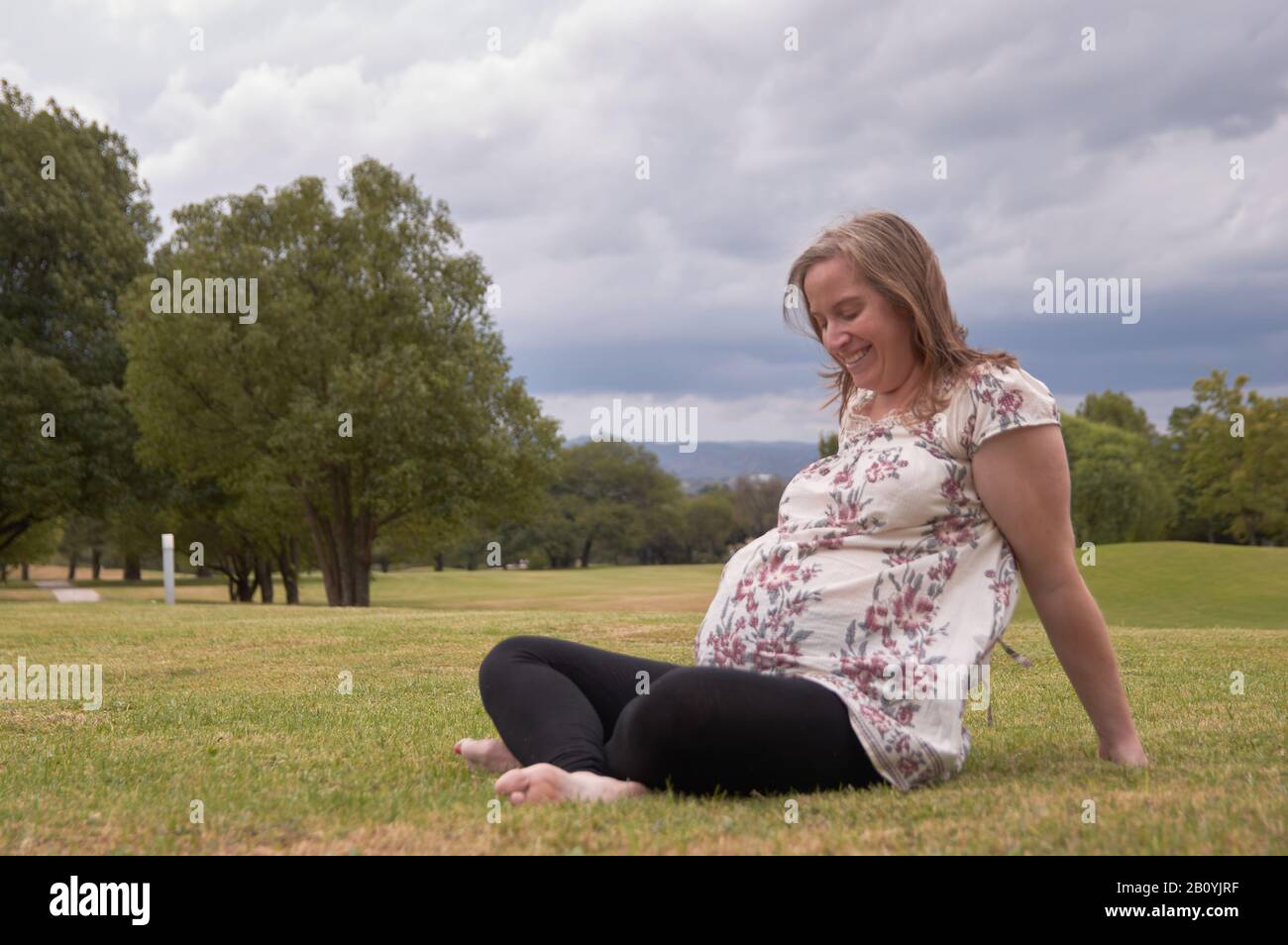 Femme enceinte de 30 ans posant au nid avec le paysage naturel en arrière-plan Banque D'Images