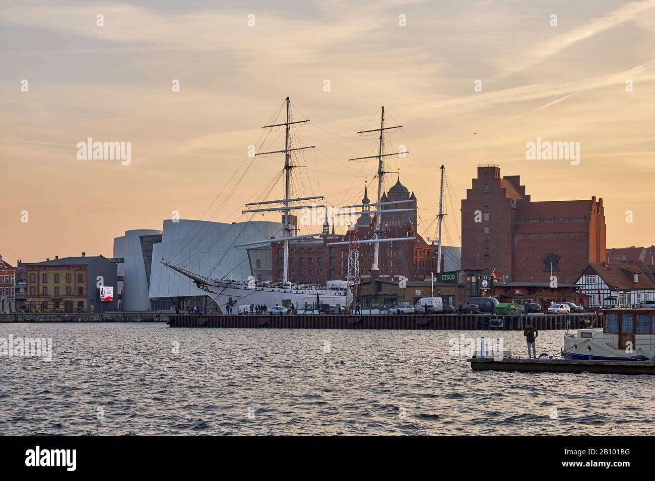 Coucher de soleil avec Ozeaneum et voilier Gorch Fock I dans le port de Stralsund, Mecklembourg-Poméranie occidentale, Allemagne Banque D'Images
