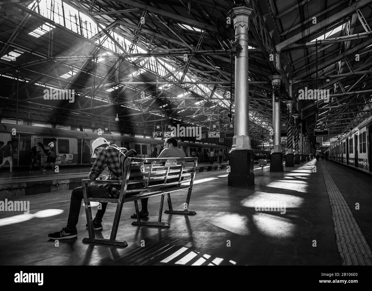 Mumbai, Inde - 18 décembre 2019 : passagers non identifiés assis sur un banc avec rayons du soleil tôt le matin à la gare CST, l'un des trains les plus bus Banque D'Images
