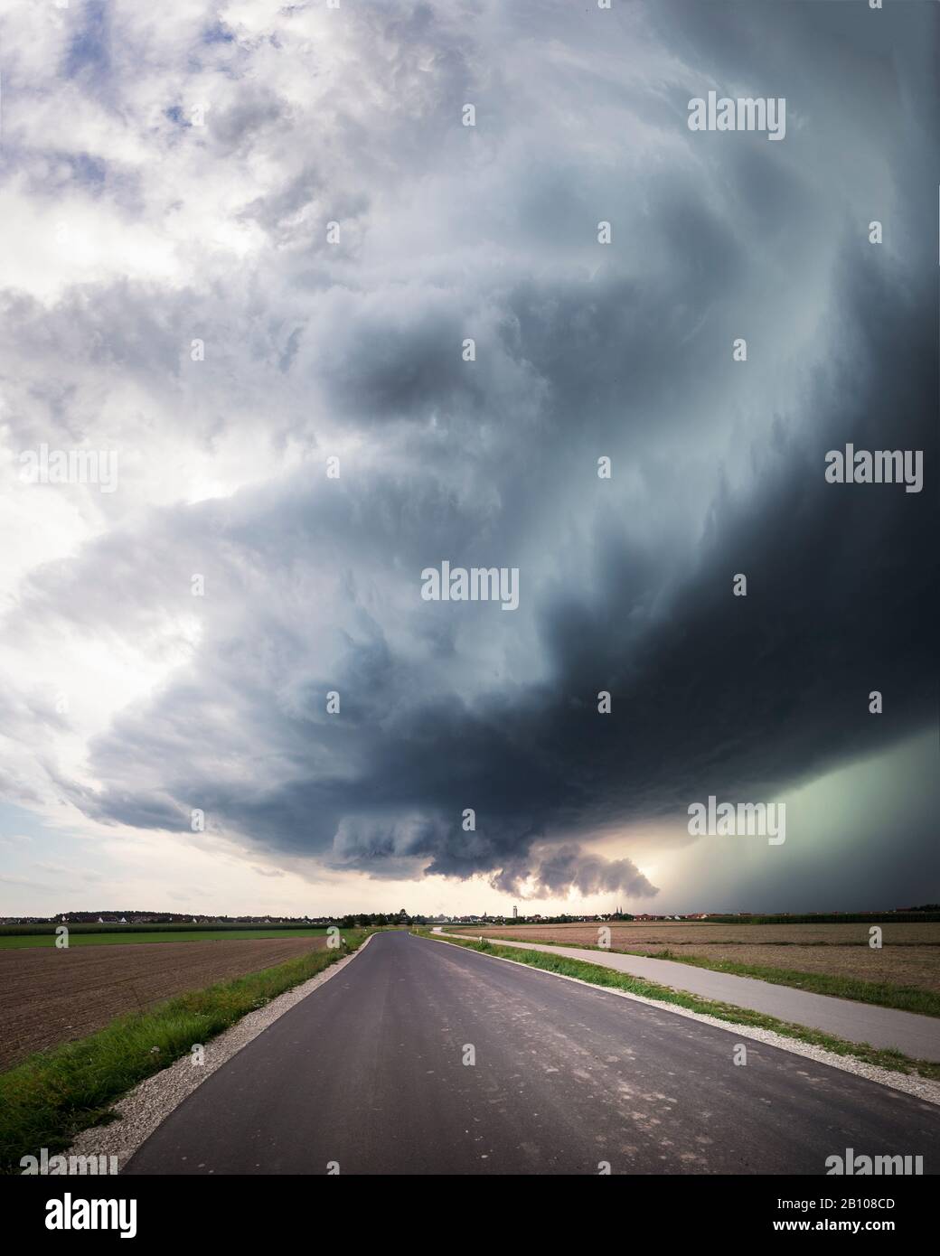 Panorama d'une super cellule avec un nuage de mur de basse altitude, une base saine de vent arrière et un noyau de précipitations vert brillant sur une route de campagne près de Heilsbronn, Bavière, Allemagne Banque D'Images Panorama d'une super cellule avec un nuage de mur de basse altitude, une base saine de vent arrière et un noyau de précipitations vert brillant sur une route de campagne près de Heilsbronn, Bavière, Allemagne Banque D'Images