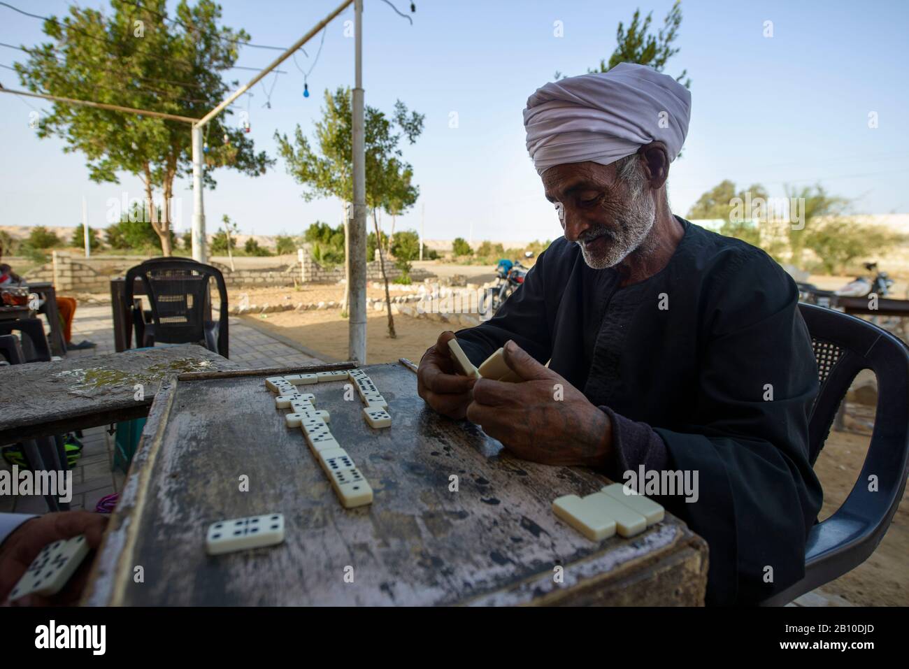 Les hommes du désert du Sahara jouent des dominos devant une maison de thé dans une oasis, en Egypte Banque D'Images
