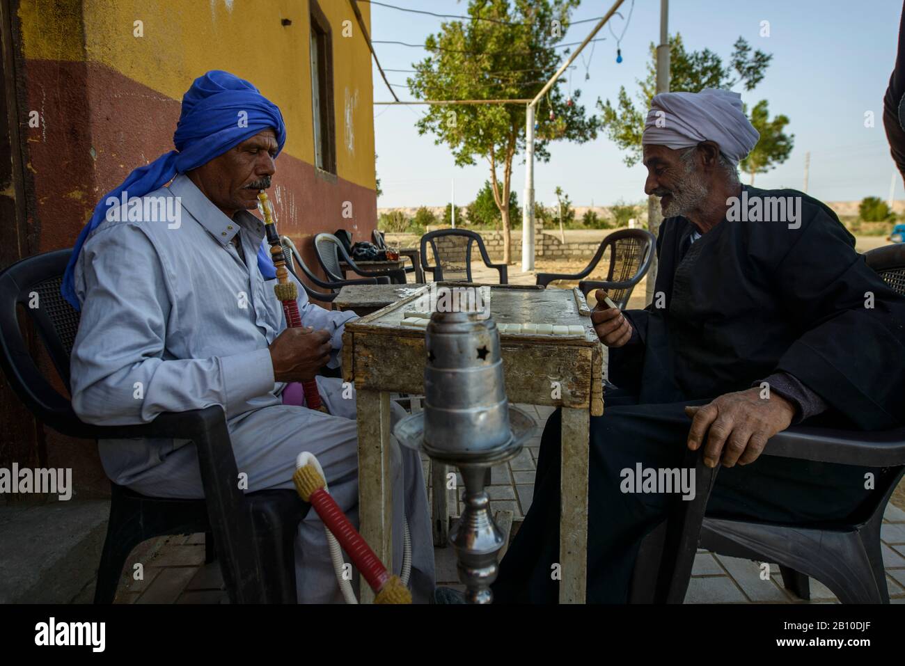 Les hommes du désert du Sahara jouent des dominos devant une maison de thé dans une oasis, en Egypte Banque D'Images