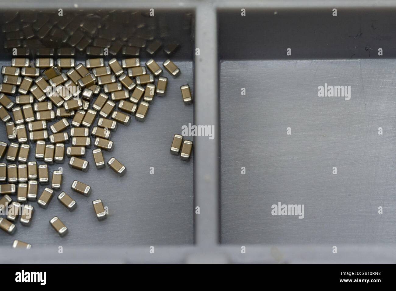 Gros plan abstrait des composants électroniques à montage en surface dans le conteneur de stockage boîte vide séparée Banque D'Images