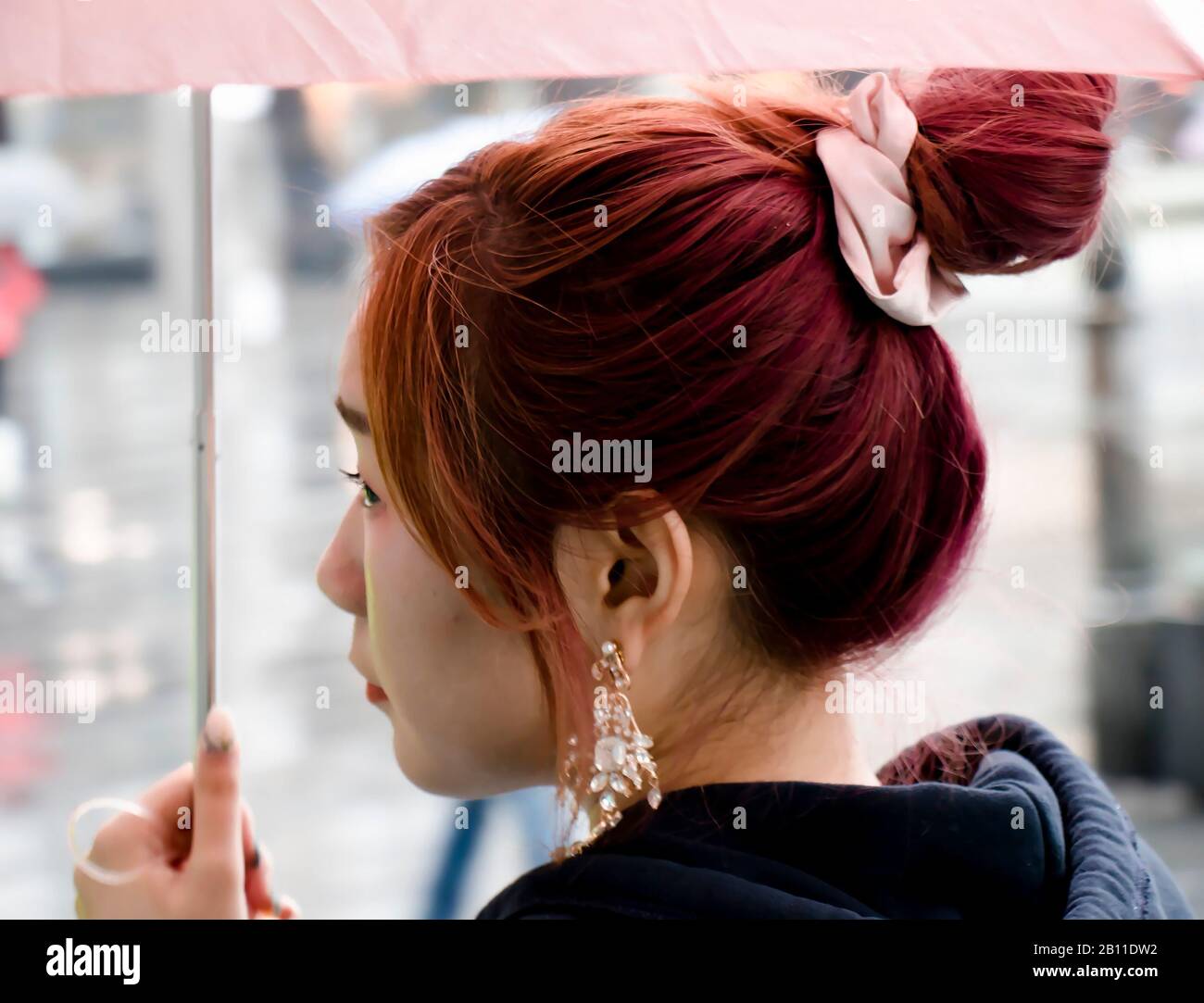 Belgrade, Serbie - 24 septembre 2019 : jeune femme asiatique de REDEHEAD marchant sous un parapluie le jour des pluies, gros plan dans le flou de mouvement Banque D'Images