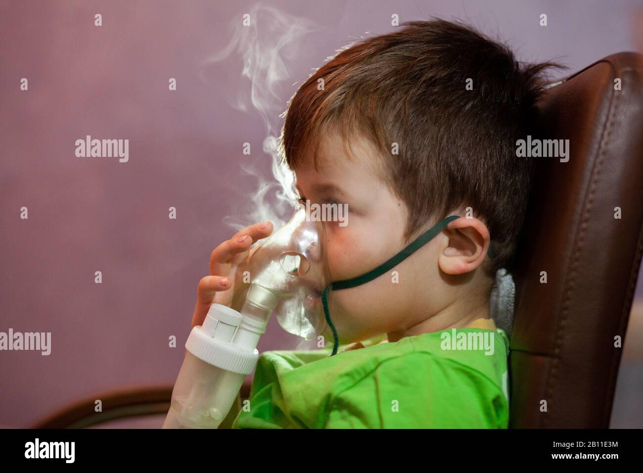 Petit Garcon Dans Un Masque Les Traitements Des Voies Respiratoires Avec Un Pulverisateur A La Maison Siege Bebe Avec Un Nebulisateur Dans Sa Bouche Inhalateur Le Traitement De La Bronchite Photo Stock