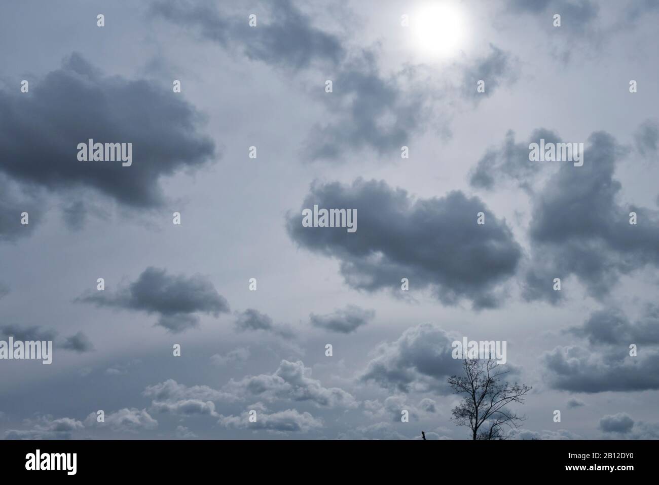 ciel nuageux avec soleil derrière les couches de nuages plus élevés Banque D'Images
