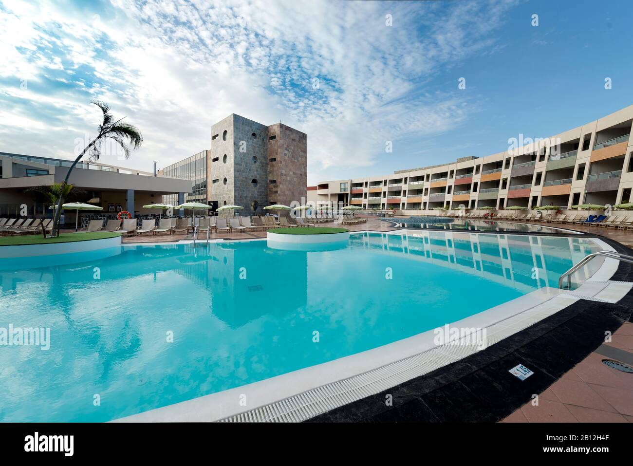 Photo d'un hôtel avec piscine à la lumière du jour. Banque D'Images