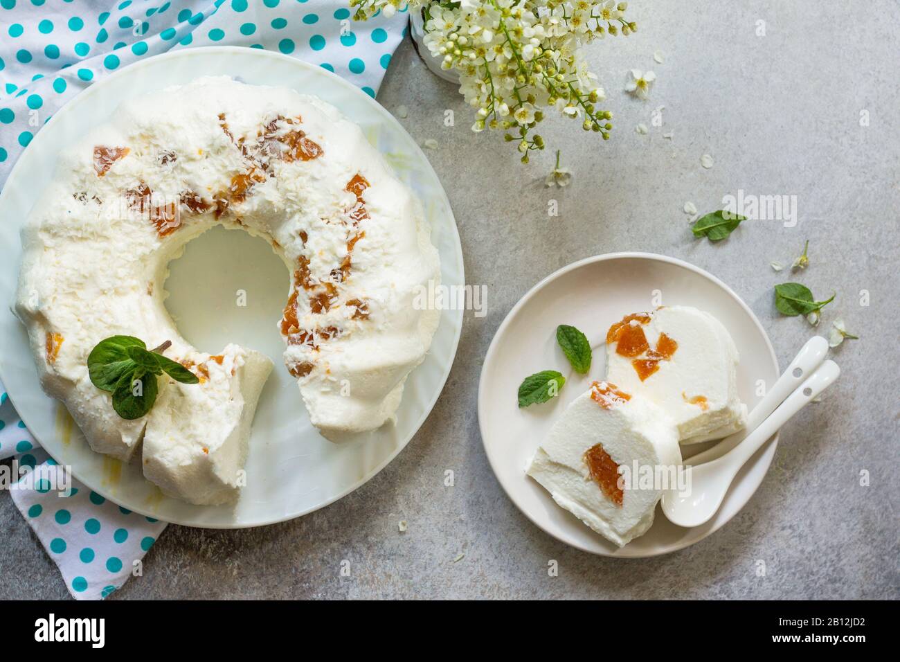 Dessert pannacotta. Cottage fromage à la soupe Panna cotta avec abricots et décor de noix de coco sur une pierre ou ardoise sur un comptoir léger. Vue sur le dessus plat cout ba Banque D'Images