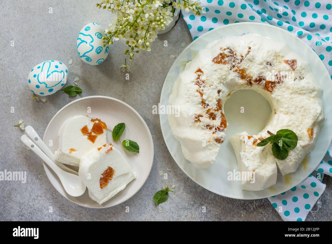 Dessert pannacotta. Cottage fromage à la soupe Panna cotta avec abricots et décor de noix de coco sur une pierre ou ardoise sur un comptoir léger. Vue sur le dessus plat cout ba Banque D'Images
