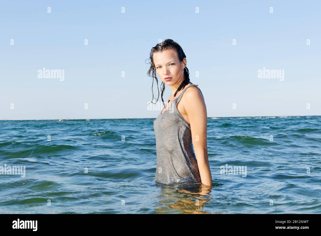Une jeune femme aux bosses d'oie se tient dans l'eau Banque D'Images