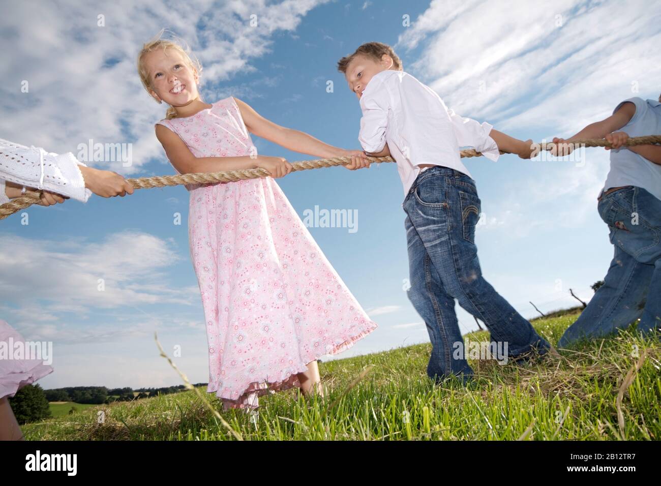 Enfants jouant au remorqueur de guerre sur un pré en été,Eyendorf,Basse-Saxe,Allemagne,Europe Banque D'Images
