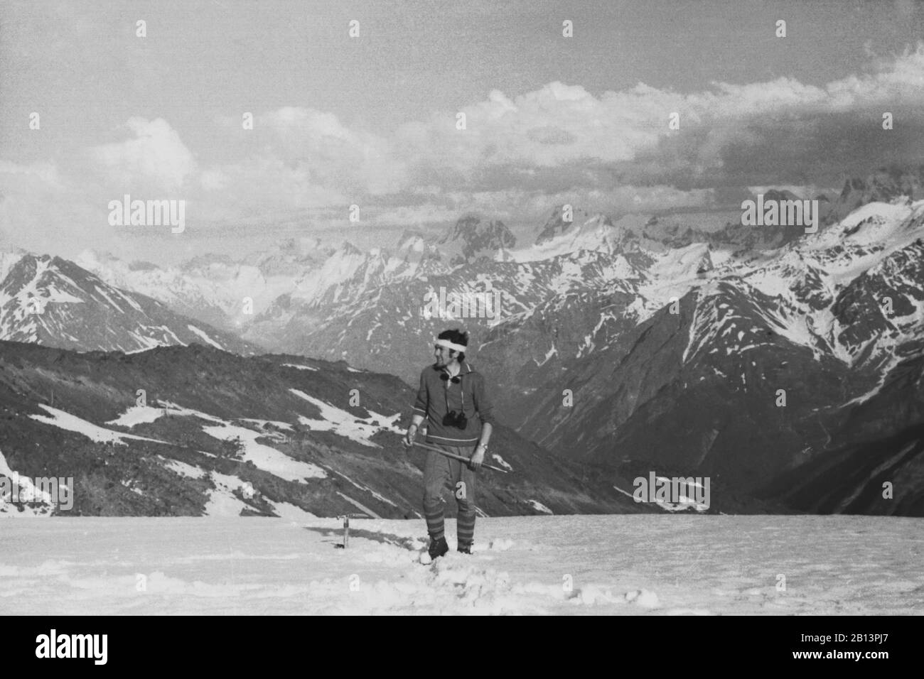 VERS 1970. grimpeur sur un halt se dresse sur un fond de montagnes avec une hache de glace et des jumelles. Montagnes du Caucase Banque D'Images