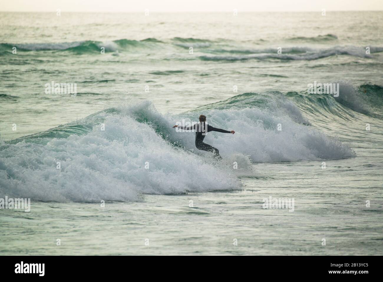 Surfeurs Au Coucher Du Soleil, Big Bay, Cape Town, Afrique Du Sud Banque D'Images
