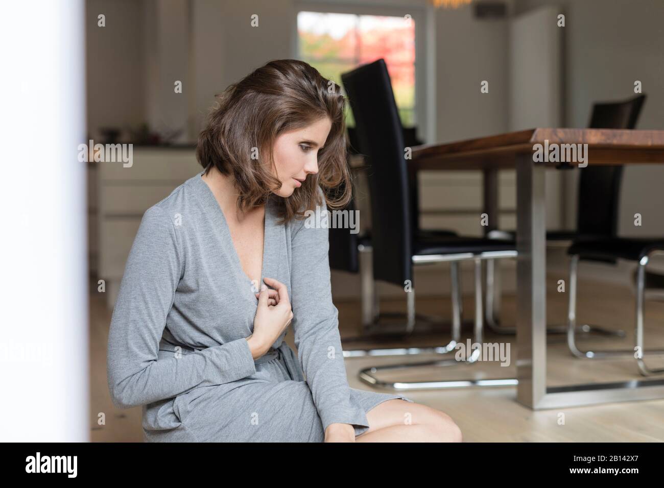 Jeune femme au sol dans la salle à manger Banque D'Images