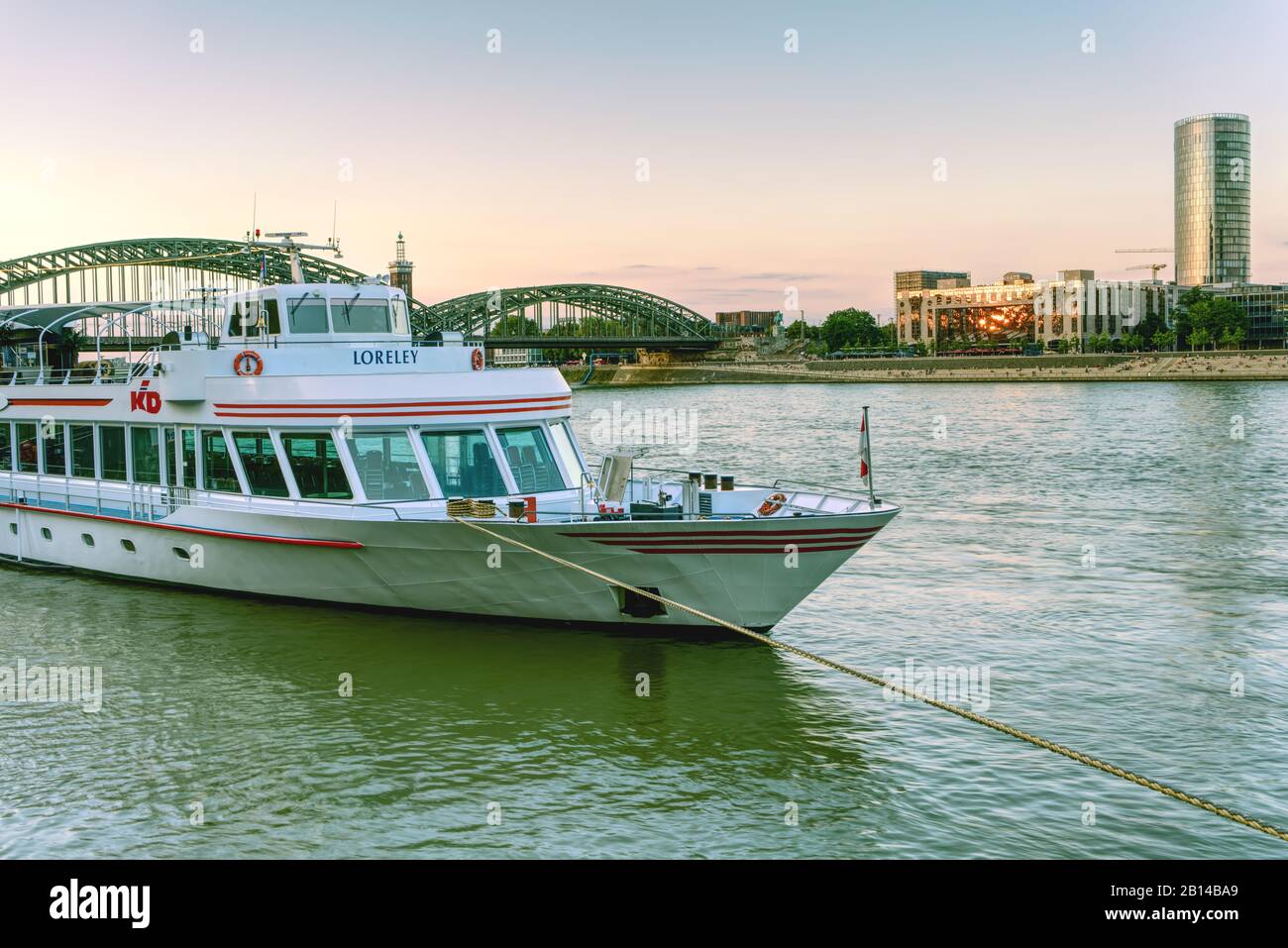 Le bateau de croisière sur le fleuve est ancré sur le Rhin à Cologne, en Allemagne. Pont Hohenzollern, hôtel Hyatt Regency et bâtiment KölnTriangle en arrière-plan. Banque D'Images
