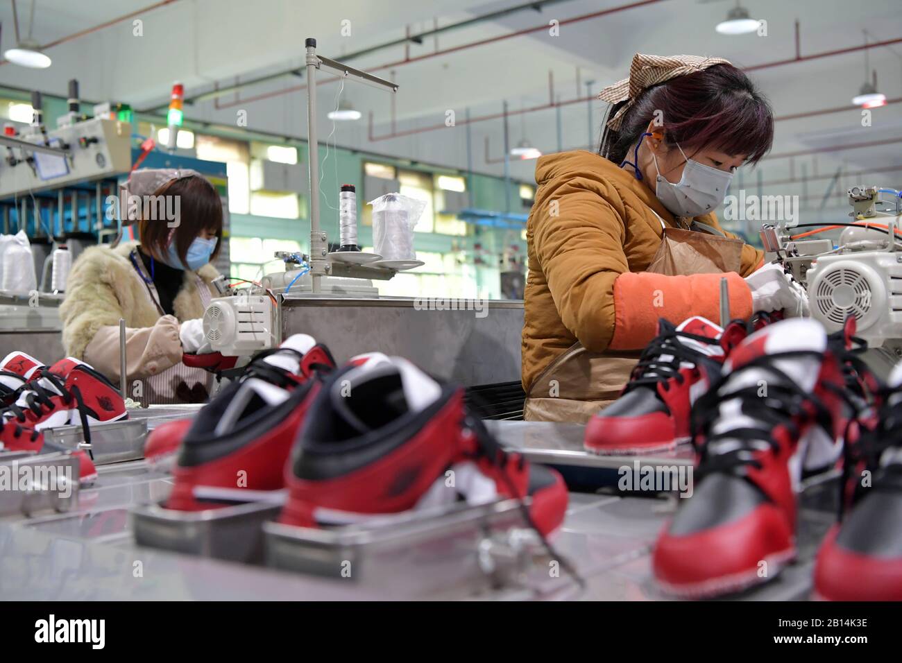 Nanchang, Province Chinoise Du Jiangxi. 22 février 2020. Les travailleurs font des chaussures dans une usine de fabrication de chaussures de la ville de Xiangtang, dans le comté de Nanchang, dans la province du Jiangxi en Chine orientale, le 22 février 2020. De nombreuses entreprises qui comptent sur les exportations ont repris leur production. Crédit: Peng Zhaozhi/Xinhua/Alay Live News Banque D'Images