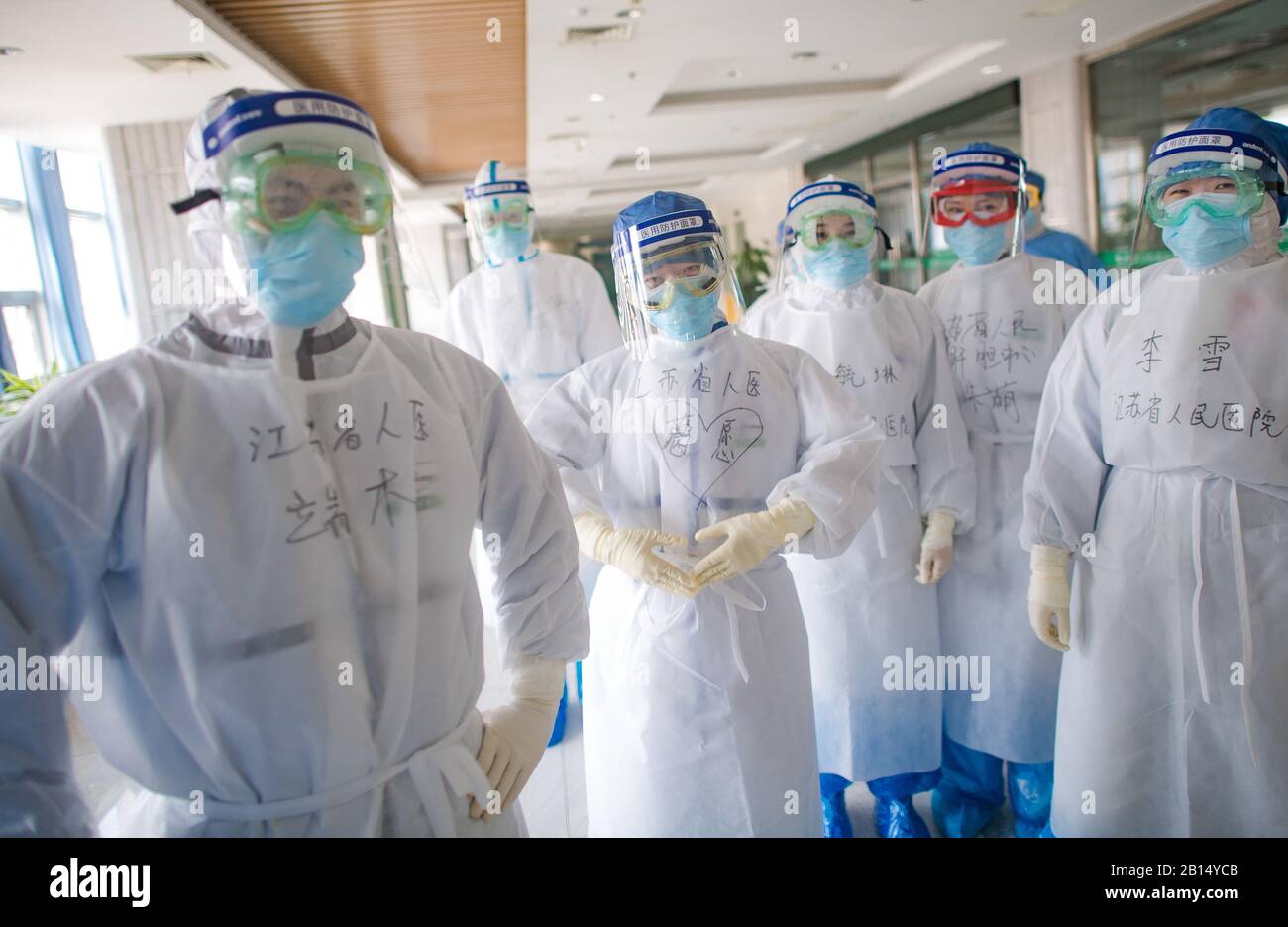 (200223) -- WUHAN, le 23 février 2020 (Xinhua) -- Ge Yuan (3ème, L), membre de l'équipe médicale de Jiangsu, donne des bénédictions à Wuhan à l'hôpital Wuhan no 1 de Wuhan, dans la province de Hubei en Chine centrale, le 22 février 2020. Le personnel médical de l'hôpital entre dans les services d'isolement en groupes et passe au travail. Chaque fois qu'ils entrent, ils doivent se préparer avec soin pendant près d'une demi-heure, porter au moins 8 pièces d'équipement par 5 portes d'isolation et travailler à l'intérieur pendant 6 heures. L'hôpital Wuhan No.1 est spécialement équipé de superviseurs pour aider le personnel médical à porter du matériel et à vérifier les omissions. Travailleurs médicaux à Wu Banque D'Images