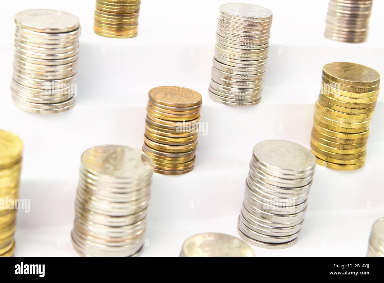 Colonnes de pièces métalliques différentes sur une échelle blanche Banque D'Images