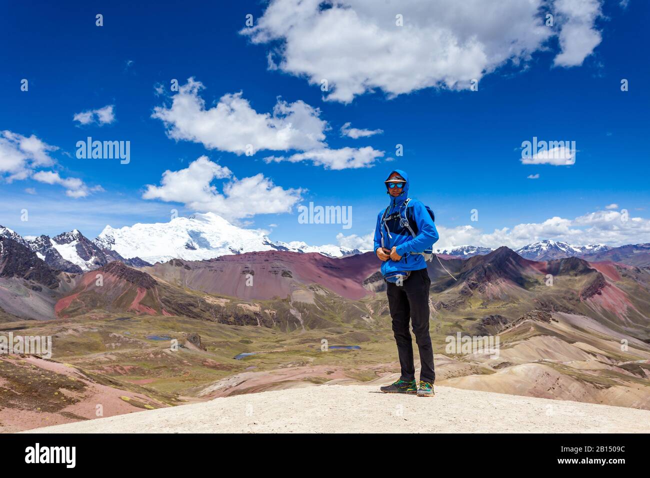 Un homme se dresse au-dessus des montagnes Rainbow Du Pérou. Andes Péruviennes. Montagne Ausangate. Banque D'Images