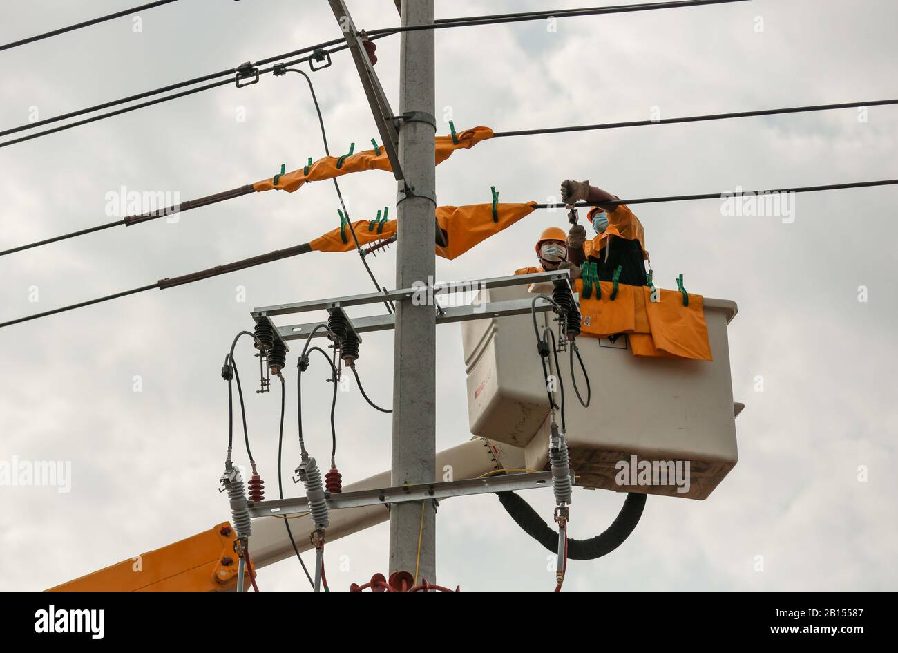 Les électriciens chinois travaillent en direct sur des lignes de transmission électrique pour sécuriser l'alimentation électrique dans le district de Langya, dans la ville de Chuzhou, dans l'est de la Chine Anhui P Banque D'Images