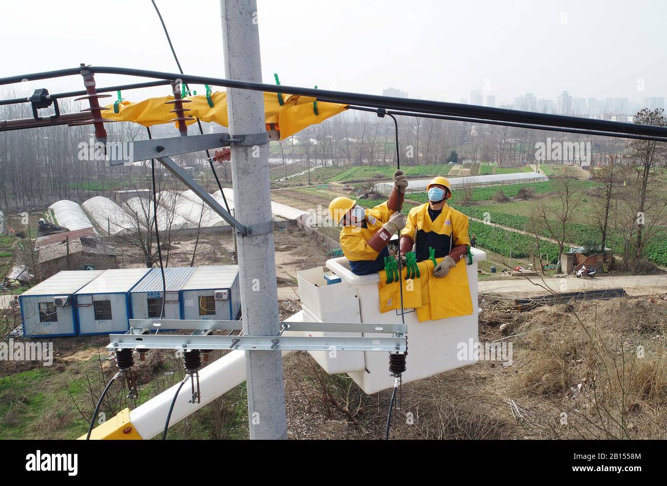 Les électriciens chinois travaillent en direct sur des lignes de transmission électrique pour sécuriser l'alimentation électrique dans le district de Langya, dans la ville de Chuzhou, dans l'est de la Chine Anhui P Banque D'Images