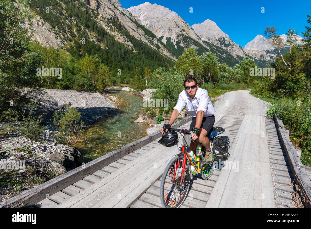 Cycliste cycliste, VTT sur le pont au-dessus du ruisseau de montagne, chemin de gravier à Karwendelhaus, vallée de Karwendel, Tyrol, Autriche Banque D'Images