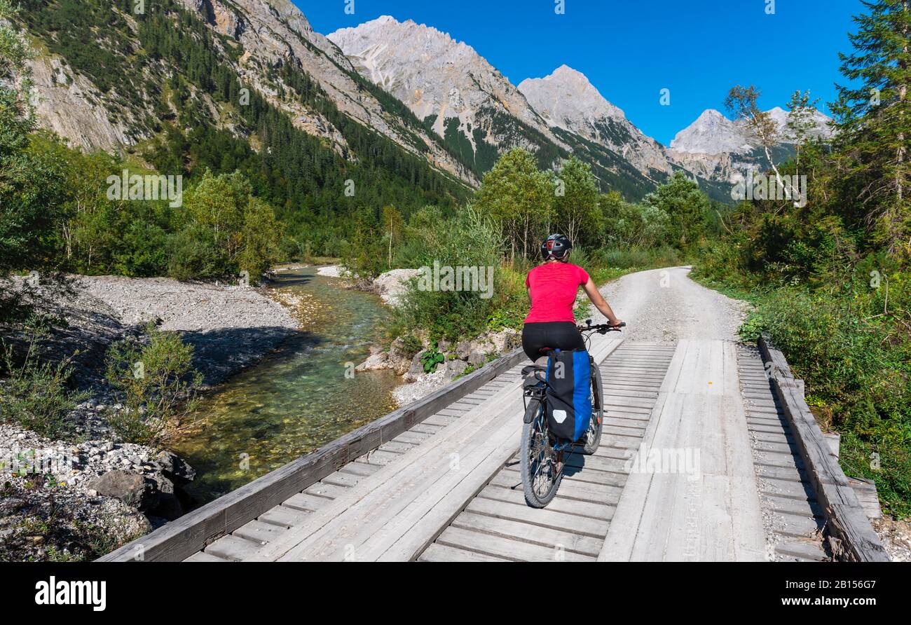 Cycliste cycliste, VTT sur le pont au-dessus du ruisseau de montagne, chemin de gravier à Karwendelhaus, Karwendeltal, Tyrol, Autriche Banque D'Images