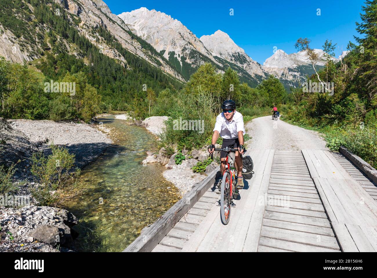 Cycliste cycliste, VTT sur le pont au-dessus du ruisseau de montagne, chemin de gravier à Karwendelhaus, vallée de Karwendel, Tyrol, Autriche Banque D'Images