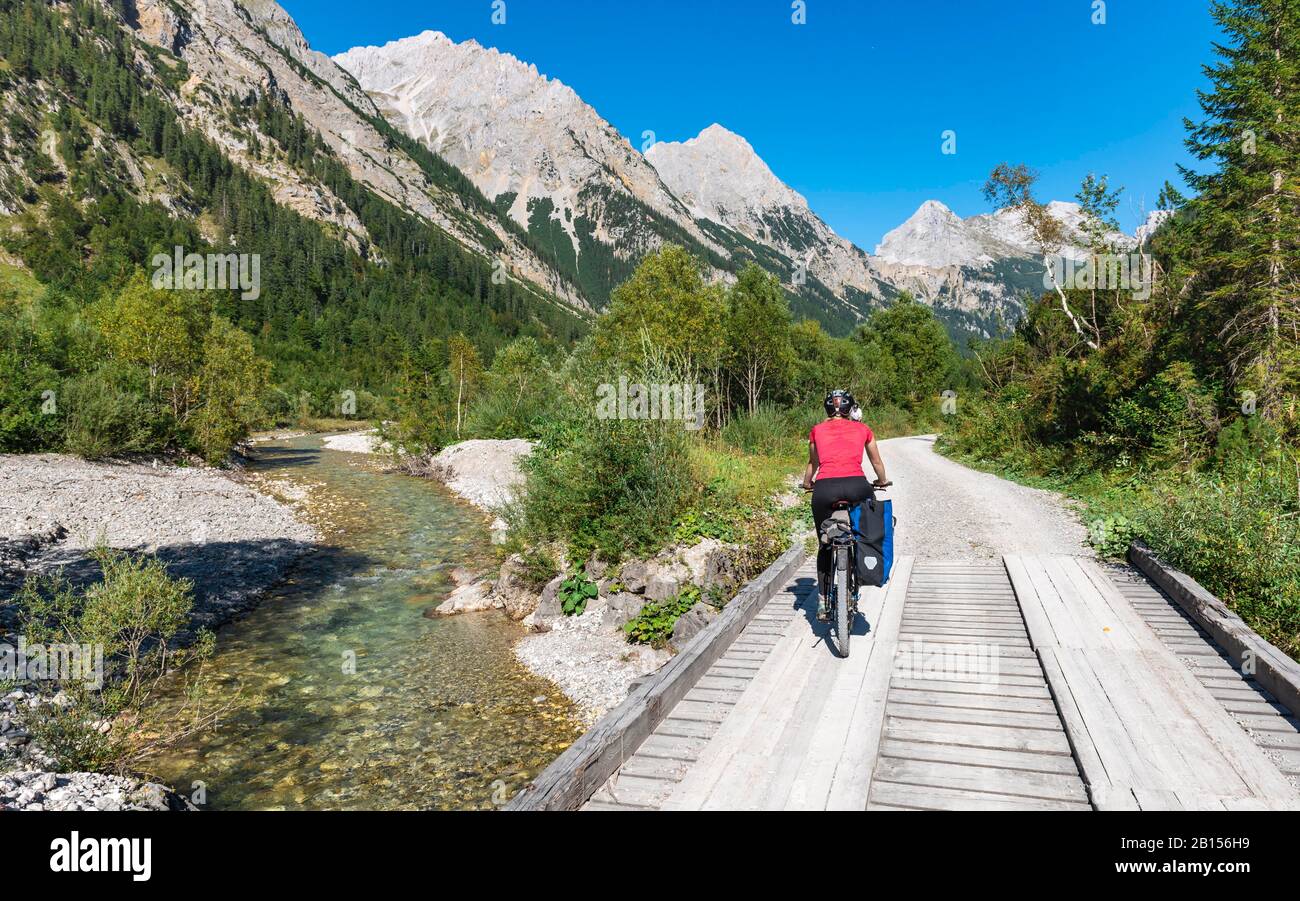 Cycliste cycliste, VTT sur le pont au-dessus du ruisseau de montagne, chemin de gravier à Karwendelhaus, Karwendeltal, Tyrol, Autriche Banque D'Images