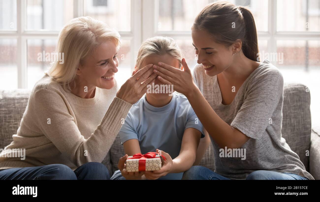 Bonne grand-mère et jeune mère d'âge moyen couvrant les yeux des filles. Banque D'Images
