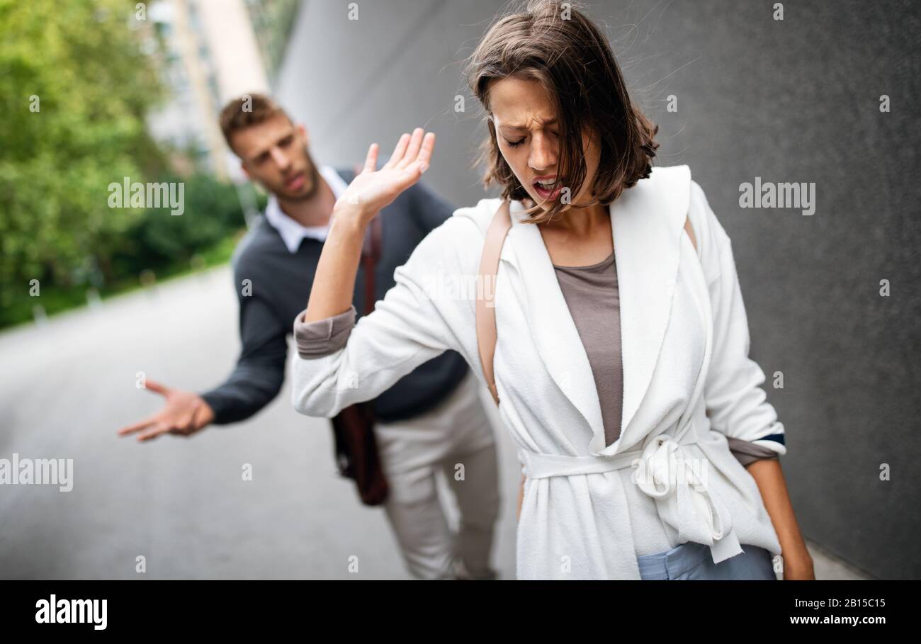 Une jeune femme triste et un homme en plein air dans la rue ayant des problèmes de relation Banque D'Images
