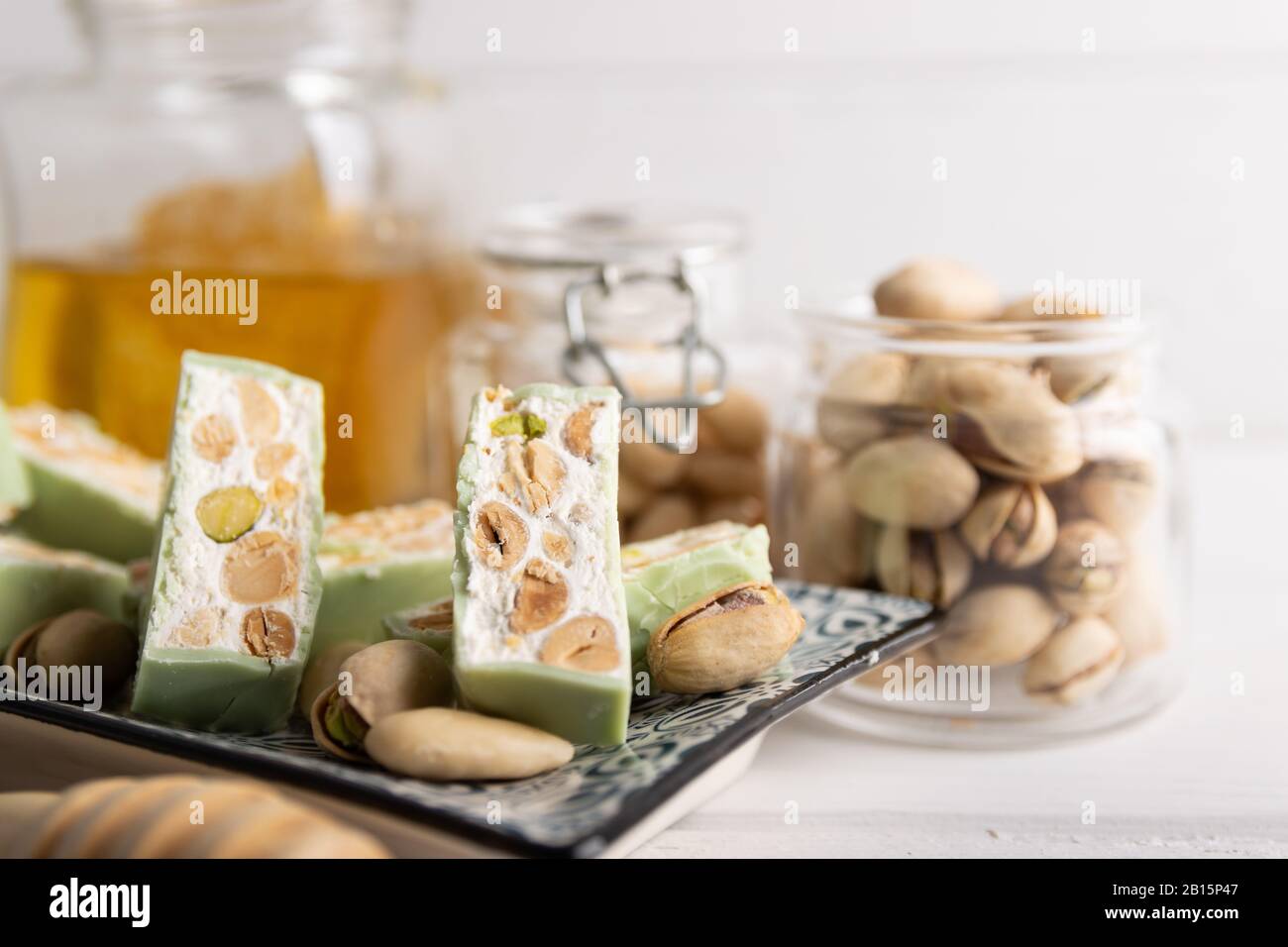 Nougat bio faites avec du miel, pistache, noisette, noix et amandes, sur un fond blanc. Banque D'Images