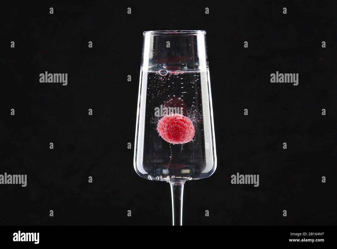 Une framboise flottante en champagne Banque D'Images