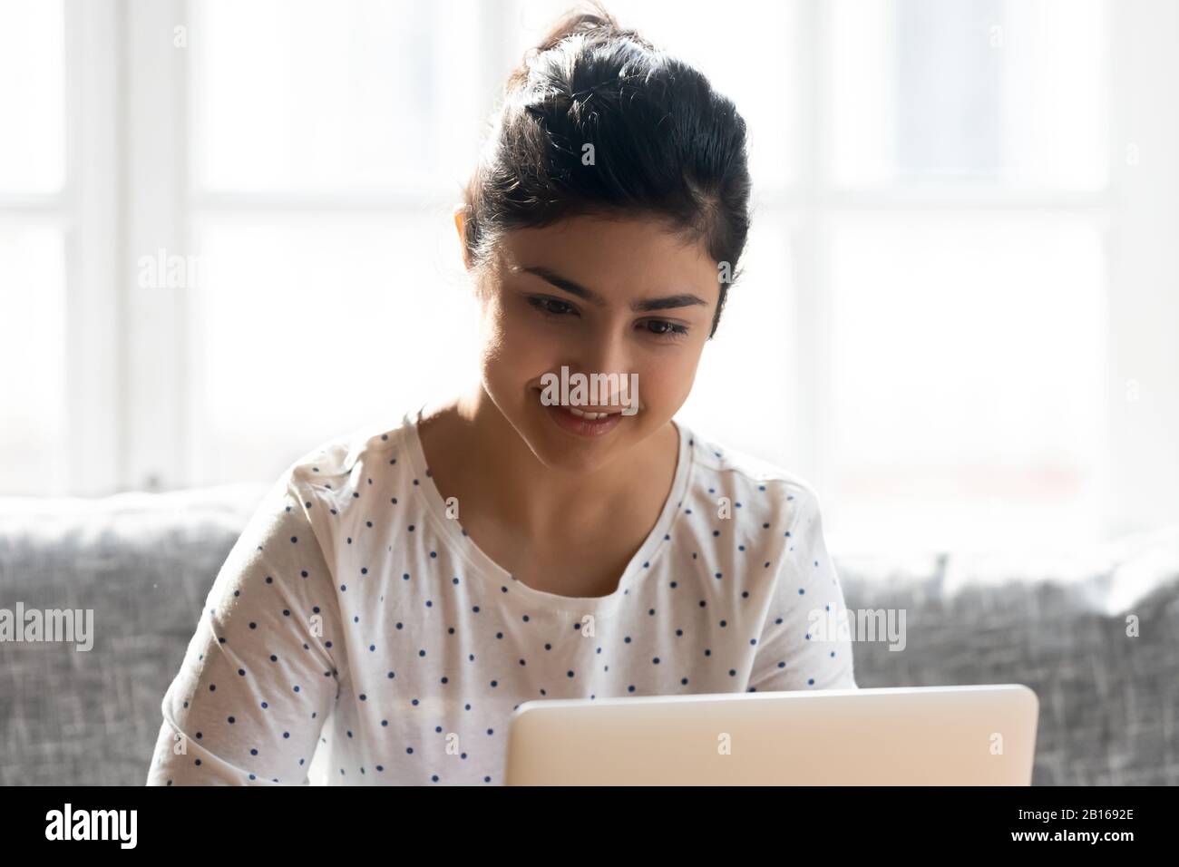 Une femme d'origine ethnique indienne faisant des achats en ligne à l'aide d'un ordinateur portable Banque D'Images